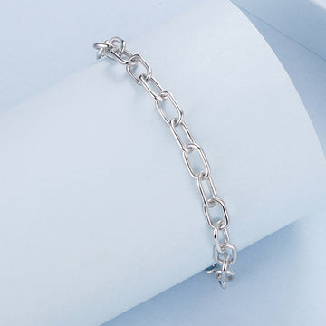 Silver chain bracelet on a light blue geometric background