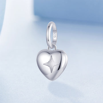 Silver heart-shaped pendant with a star engraving on a light blue background
