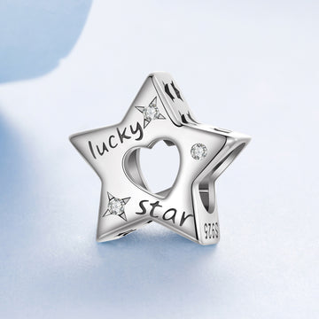 Silver star-shaped charm with 'lucky star' engraving on a light blue background