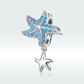 Starfish-shaped charm with blue gemstones on a light gray background