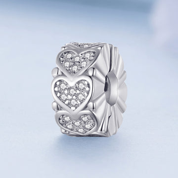 Silver charm with heart designs on a light blue background
