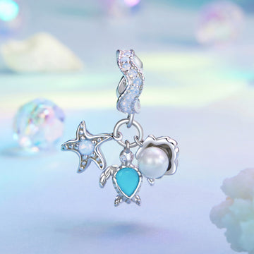 Silver earring with star, moon, and heart charms on a soft, multicolored background