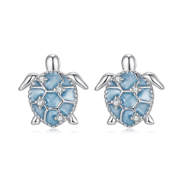Turtle-shaped earrings with blue enamel and clear stones on a white background