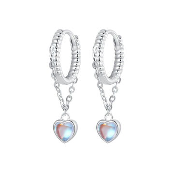 Silver hoop earrings with heart-shaped charms on a white background