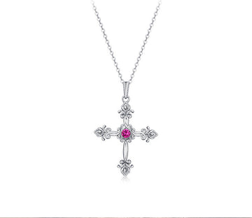 Silver cross necklace with a pink gemstone on a white background, featuring the text 'As Unique As You'.