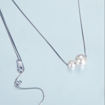 Pearl necklace with a shell on a light blue background