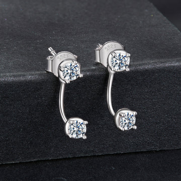 Silver earrings with clear gemstones on a black background