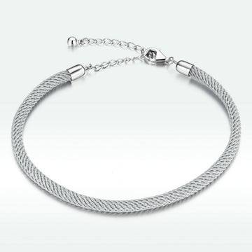 Silver bracelet with a textured band on a white background