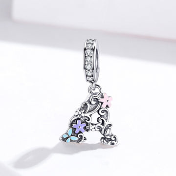 Silver pendant with floral designs and colorful stones on a white background