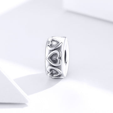 Silver ring with heart designs on a white background