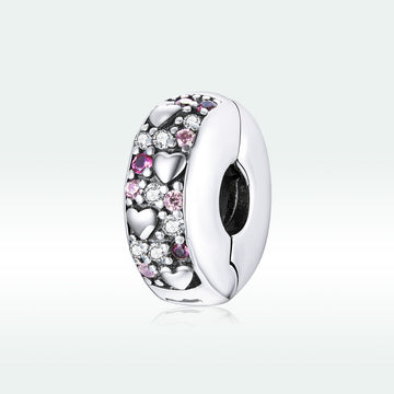 Silver charm with pink and clear stones on a light gray background
