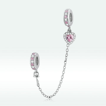 Silver charm with pink stones on a white background