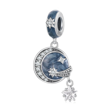 Silver charm with star and moon design on a white background