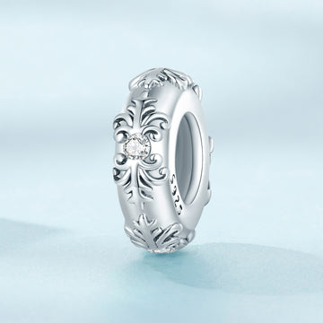 Silver ring with intricate design on a light blue background