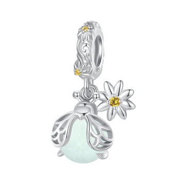 Silver charm with floral design and gemstones on a white background