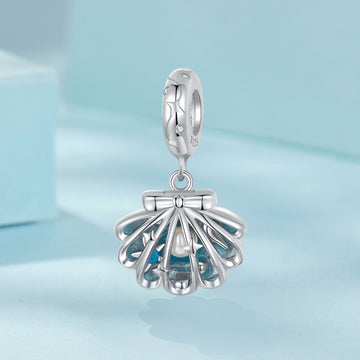 Silver shell charm with blue interior on a light blue background