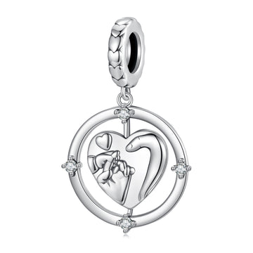 Silver pendant with heart design and small figure, on a white background
