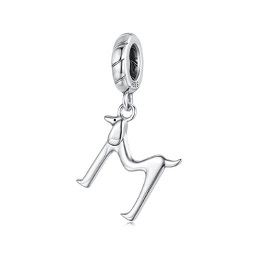 Silver charm shaped like a dog on a white background