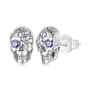 Silver skull earrings with purple gemstones on a white background
