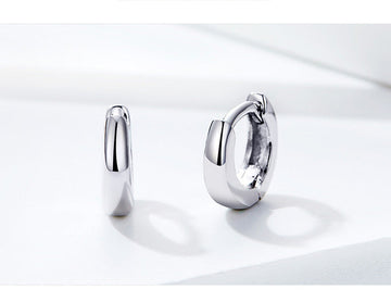 Silver hoop earrings on a white background with a motivational quote.