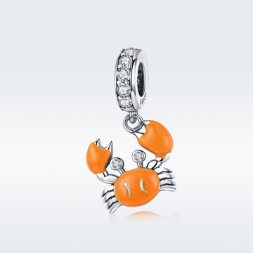 Silver charm with orange crab design on a white background
