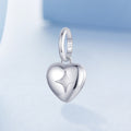 Silver heart-shaped pendant with a star engraving on a light blue background