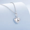 Silver heart-shaped pendant necklace on a light blue background