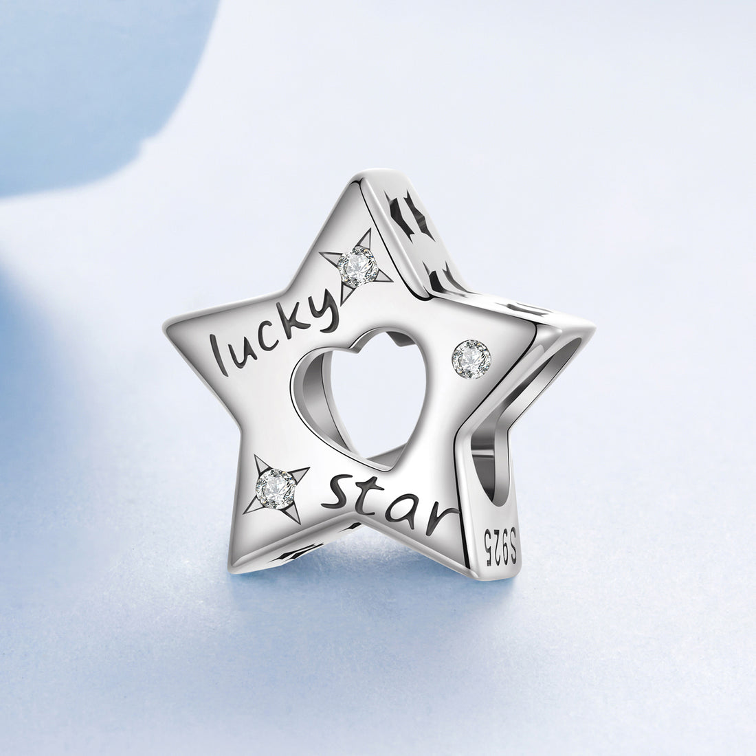 Silver star-shaped charm with 'lucky star' engraving on a light blue background