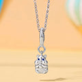 Silver cat-shaped pendant on a chain against a blurred background