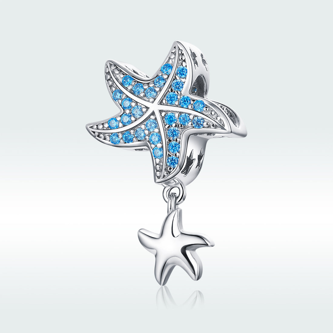 Starfish-shaped charm with blue gemstones on a light gray background