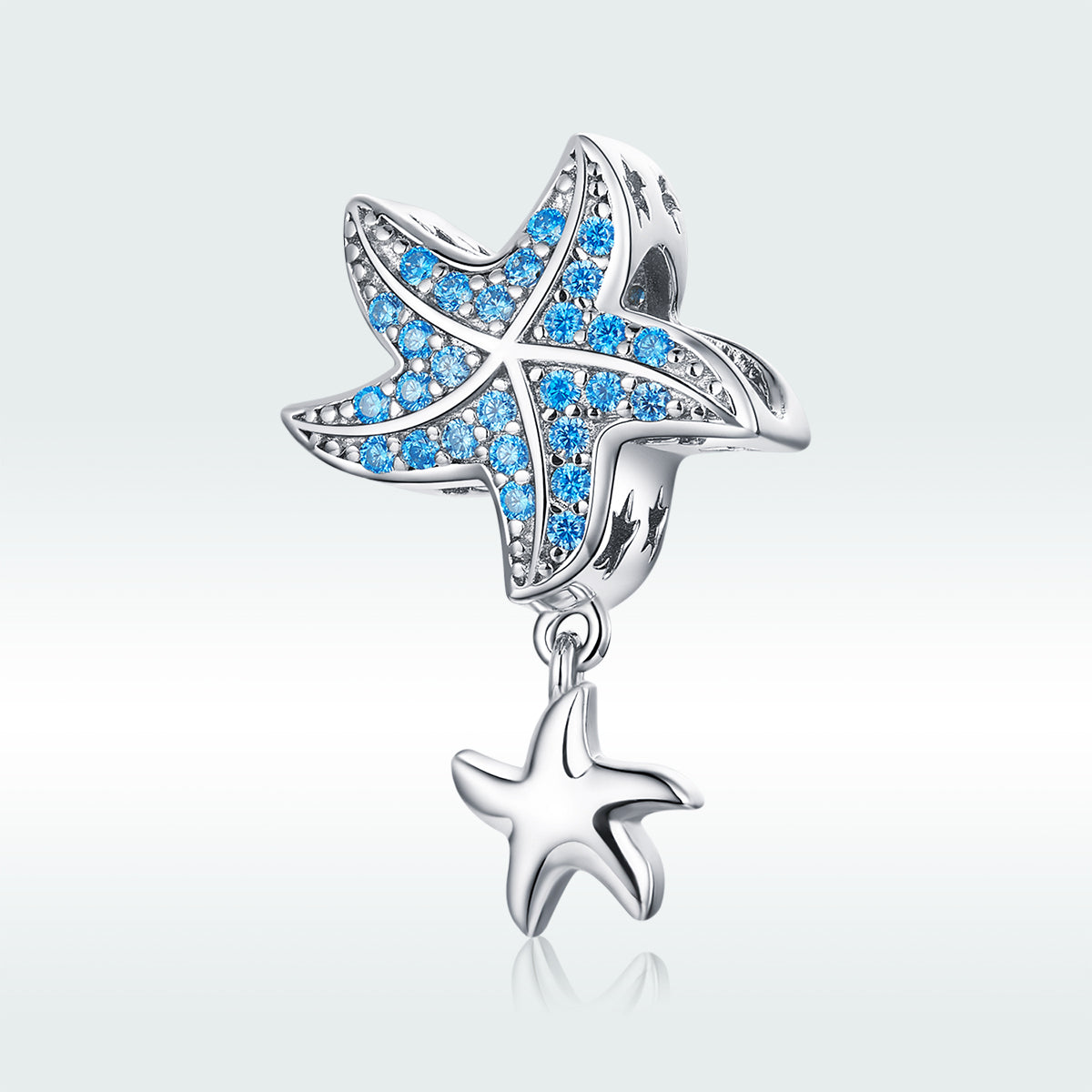 Starfish-shaped charm with blue gemstones on a light gray background