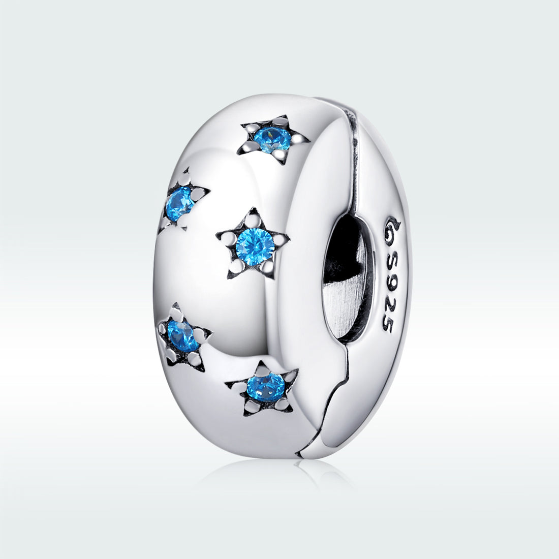 Silver charm with blue gemstones on a white background