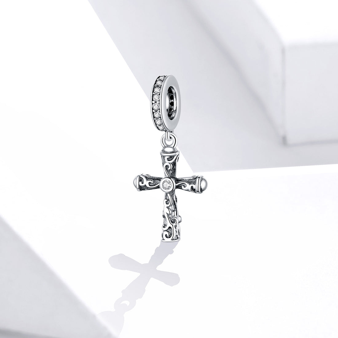 Silver bracelet with a cross charm on a white background