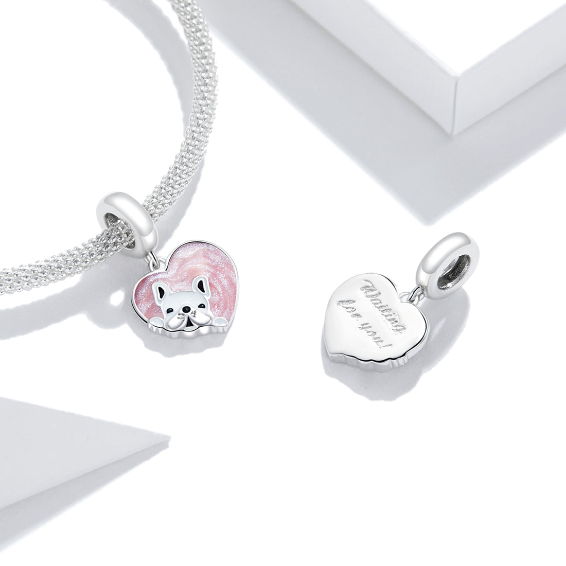 Silver charm with a pink heart and dog design on a white background