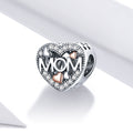 Heart-shaped silver charm with 'MOM' and heart designs on a white background