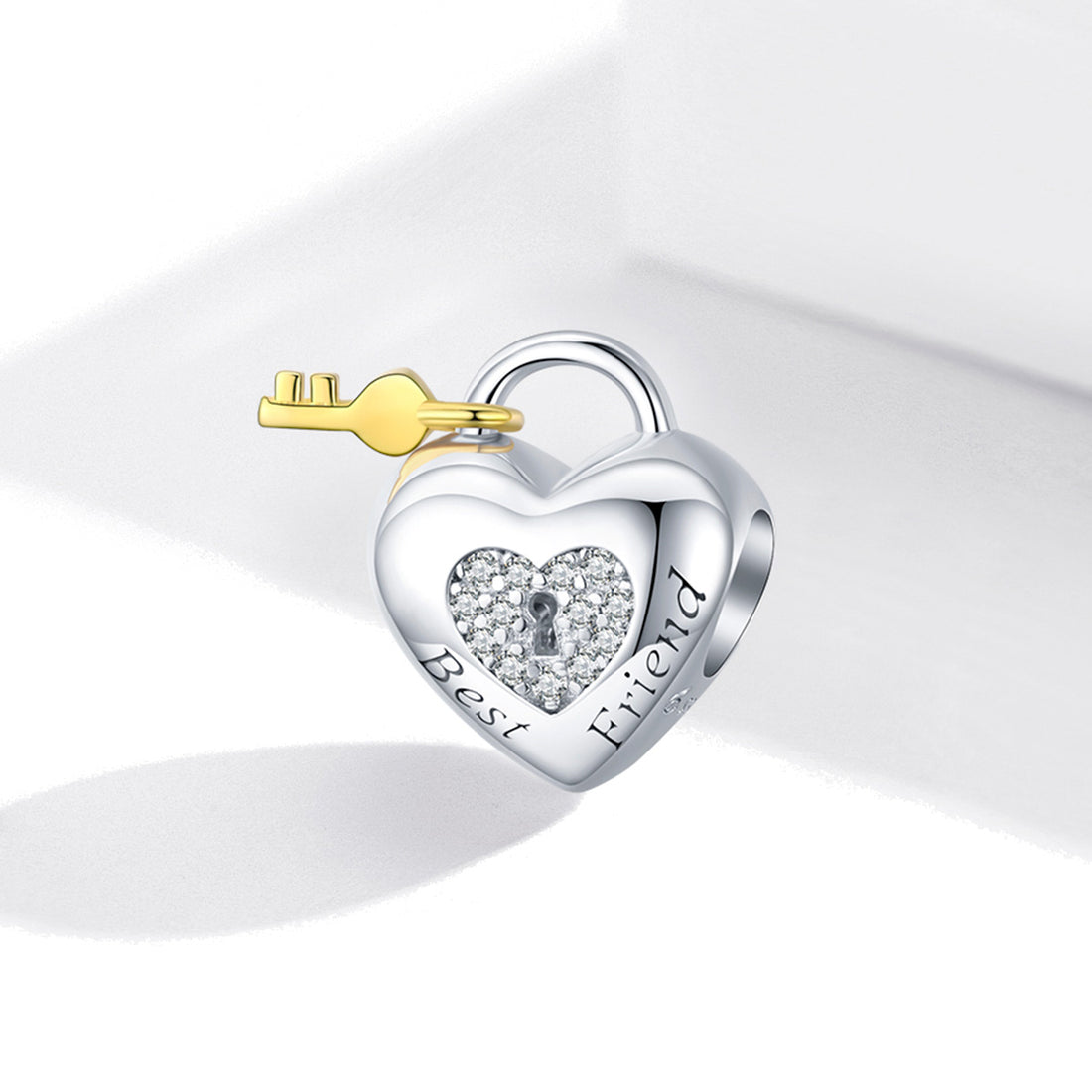 Heart-shaped silver lock with a gold key on a white background