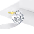 Heart-shaped silver lock with a gold key on a white background