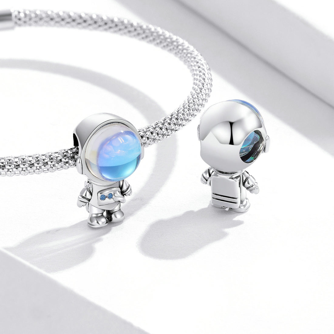 Silver charm with a colorful gem on a white background