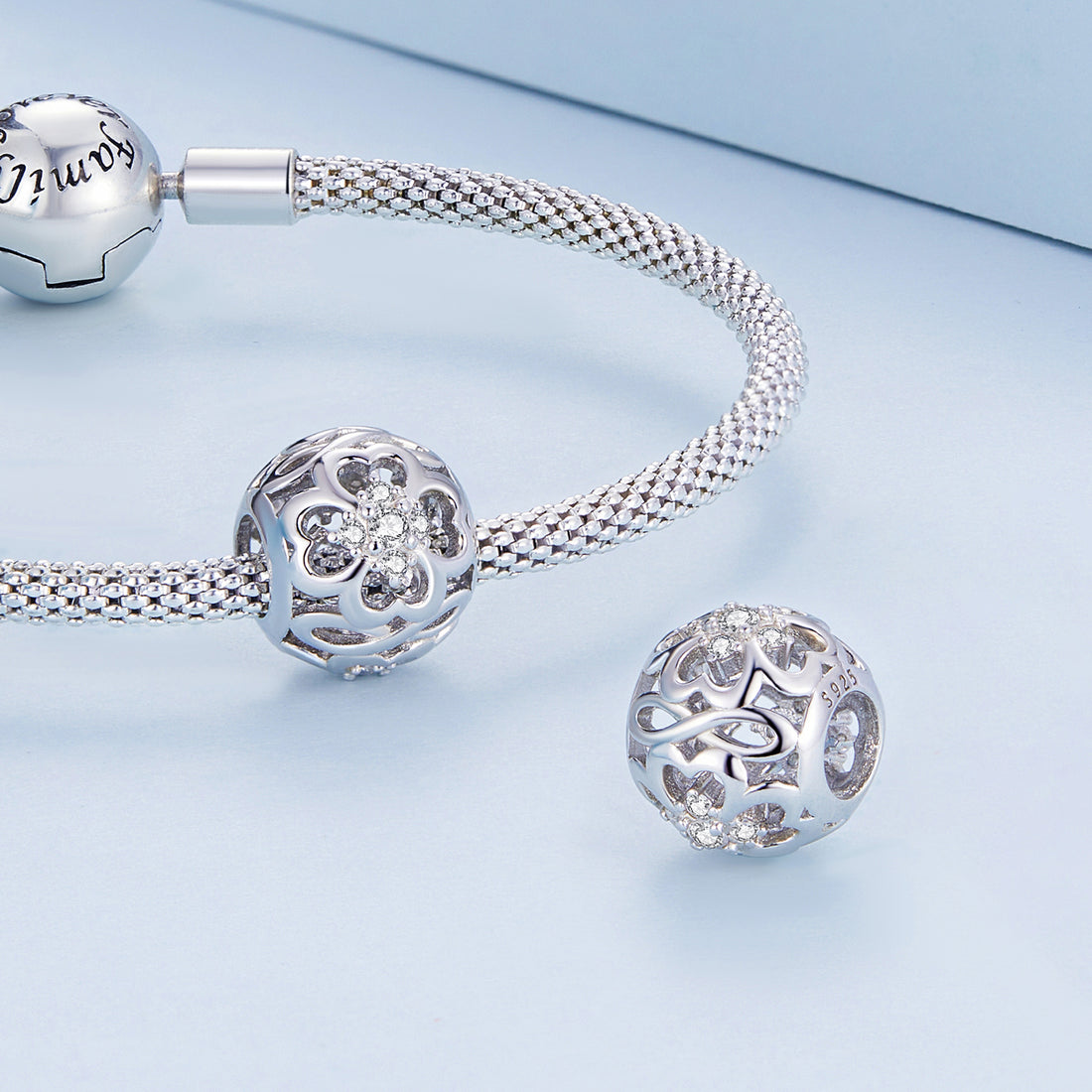 Silver bracelet with decorative beads on a light blue background