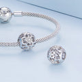 Silver bracelet with decorative beads on a light blue background