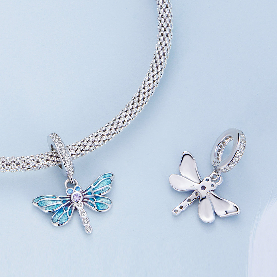 Blue butterfly charm with clear gemstones on a white background