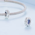 Silver bracelet and earrings on a light blue background