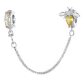 Silver bee-shaped charm with yellow gemstone on a white background