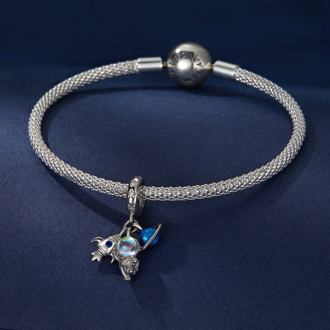 Silver charm with space-themed elements including a rocket, moon, and planet on a white background