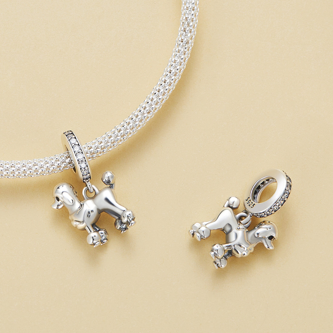 Silver poodle charm with a clear gemstone on a white background