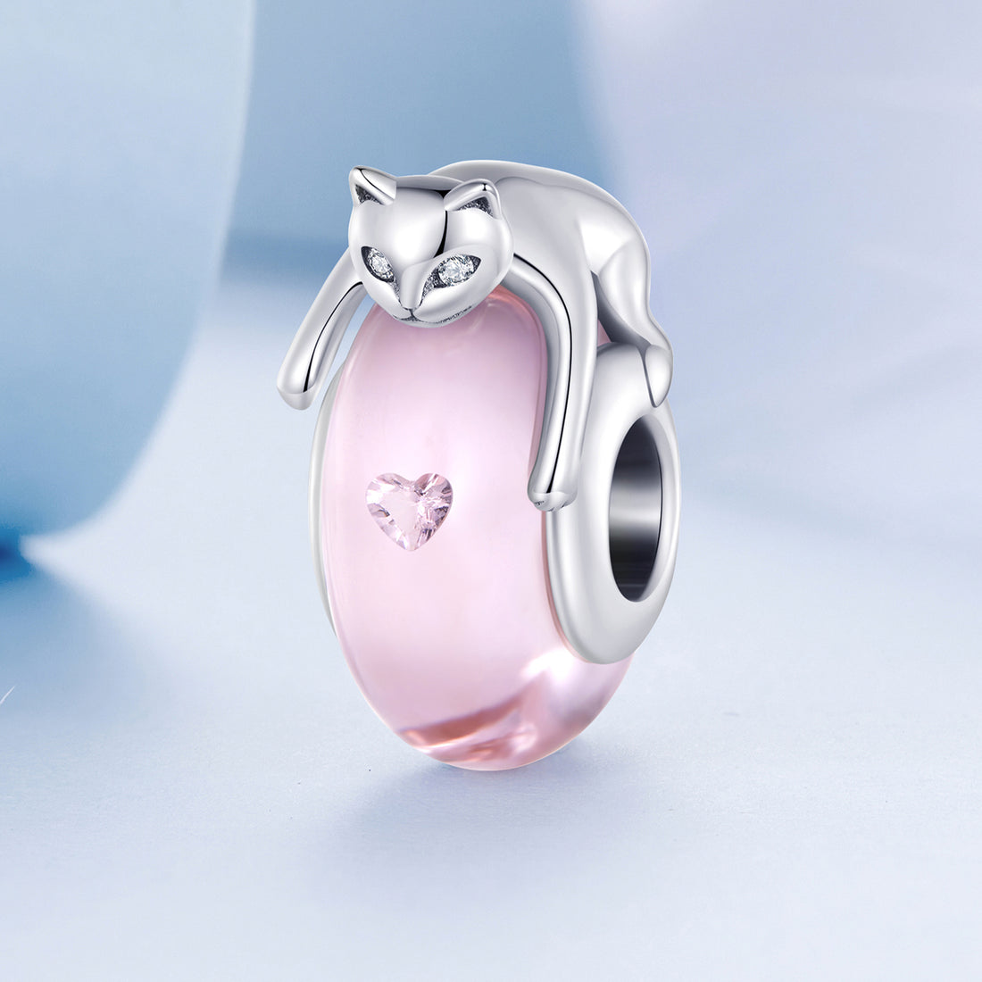 Pink cat-shaped charm with a silver outline on a light blue background