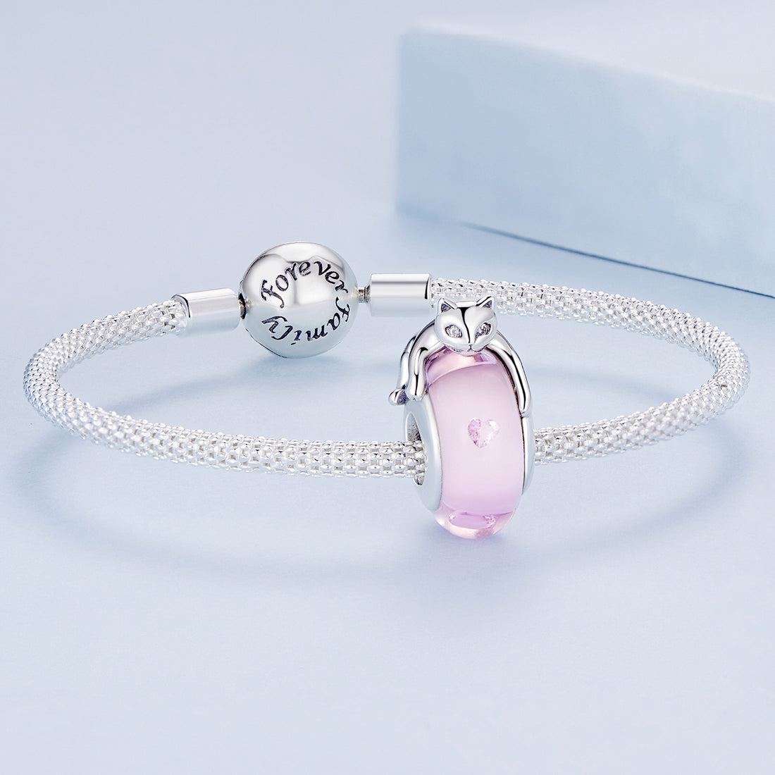 Pink cat-shaped charm with a silver outline on a light blue background