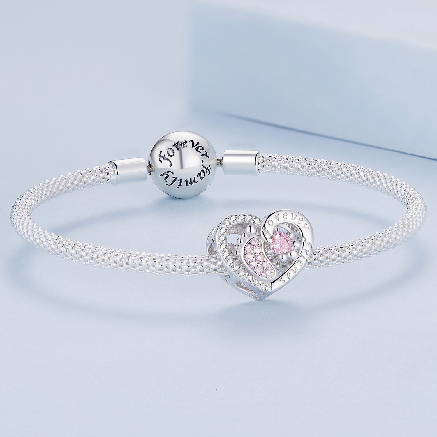 Silver bracelet with heart-shaped charm and 'Forever Yours' bead on a light blue background