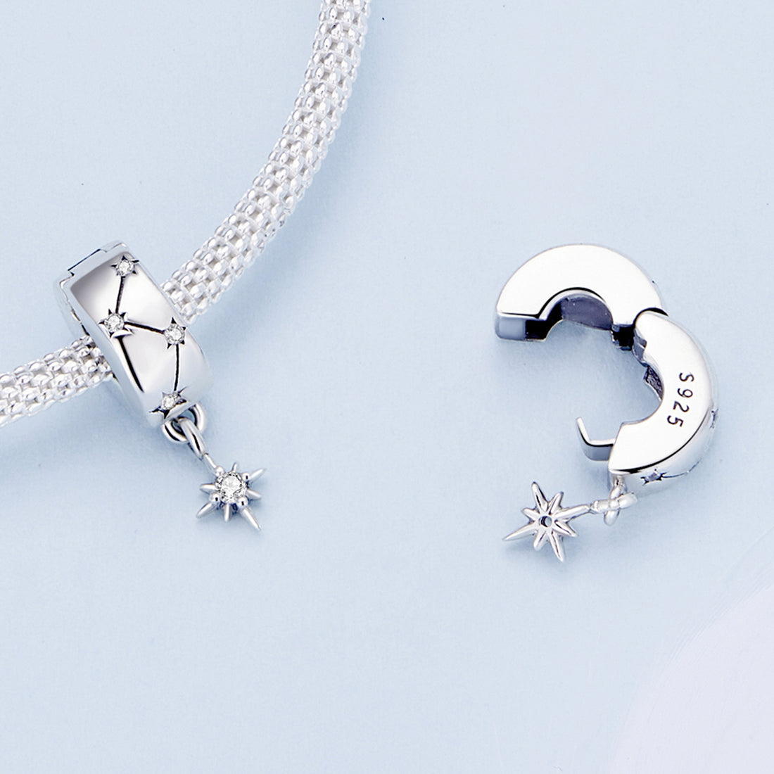 Silver charm with star design on a white background