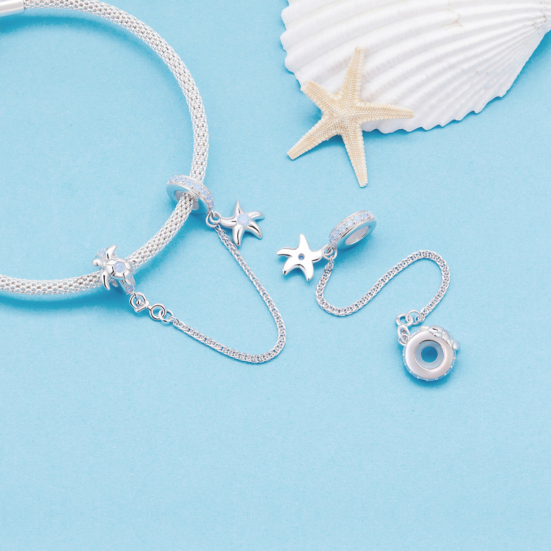 Silver charm with starfish and turtle design on a white background